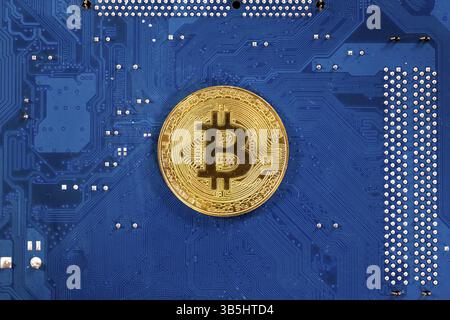 Cryptocurrency virtuelle Bitcoin argent médaille d'or sur un ordinateur à circuit imprimé (PCB). L'avenir de l'argent. L'équipement informatique. Mère bleu bo Banque D'Images