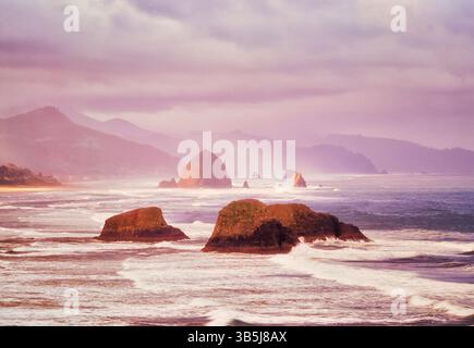 Lever de soleil et nuages et brouillard avec des vagues. Cannon Beach. Oregon Banque D'Images