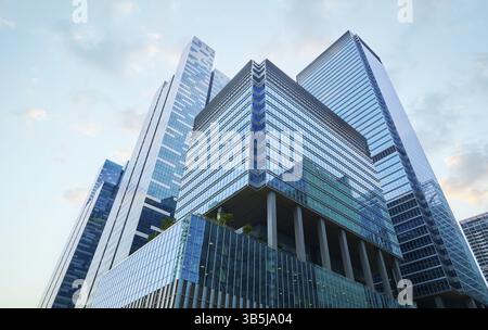 Les gratte-ciels en verre reflétant le ciel bleu créent une image puissante de l'architecture moderne et du succès commercial à singapour Banque D'Images