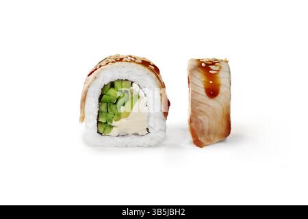 Deux morceaux de sushi uramaki, mettant en valeur sa garniture d'avocat et de fromage à la crème, garnie de sauce teriyaki et de graines de sésame Banque D'Images