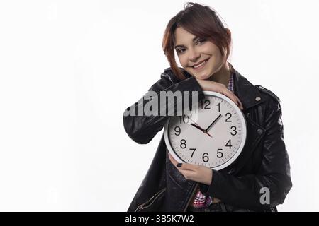 Une jeune femme joyeuse pose joyeusement avec une horloge, incarnant magnifiquement des thèmes du temps et un style de vie dynamique Banque D'Images