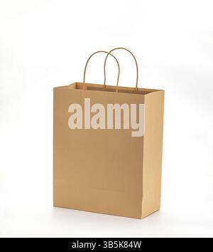 Un sac à provisions en papier brun avec des poignées robustes se dresse sur fond blanc Uni, mettant en valeur son design écologique et sa simplicité Banque D'Images