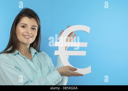 DAS Maedchen haelt ein grosses Euro-Symbol dans ihren Haenden. Union Form der Waehrung der Europaeischen. Symbol fuer Finanzen und Cashflow in der Wirts Banque D'Images