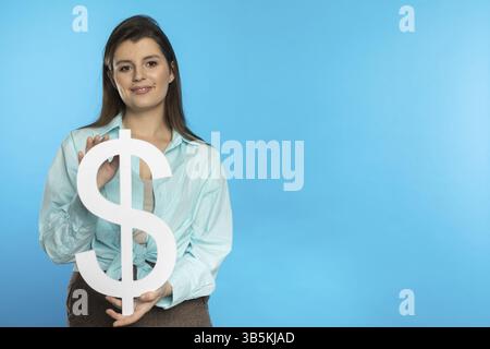 DAS Maedchen haelt ein grosses Dollarsymbol dans ihren Haenden. Die Form der US-Waehrung. Symbol fuer Finanzen und Cashflow in der Wirtschaft und der Bï¿½ Banque D'Images