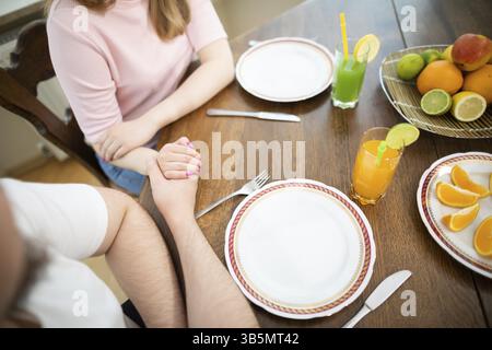 Sur le comptoir se trouvent des bananes, des pommes, des limes et des oranges. Certains fruits sont tranchés. À côté d'eux se tiennent des boissons colorées dans de grands verres avec des pailles Banque D'Images