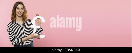 DAS Maedchen haelt ein grosses Pfund symbole dans ihren Haenden. Grossbritannien-Waehrungsform. Symbol fuer Finanzen und Cashflow in der Wirtschaft und d Banque D'Images