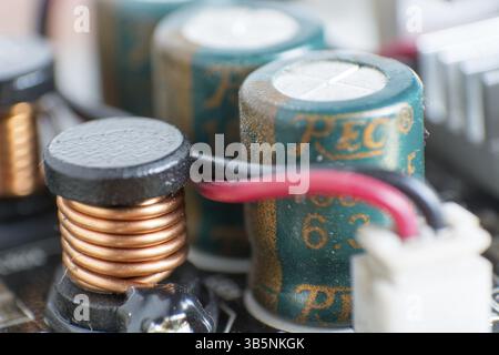 Composants informatiques poussiéreux. Détail d'une carte mère d'ordinateur poussiéreuse. Condensateur électrolytique et conducteur visibles sur la carte de circuit imprimé. Sélectiv Banque D'Images