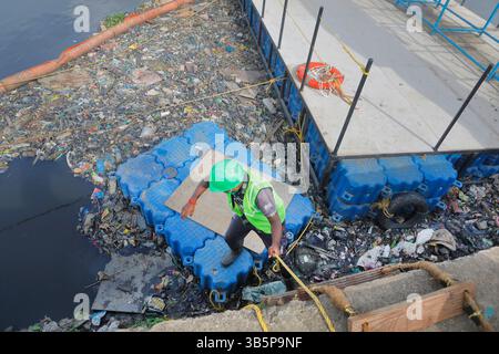 10 août 2021, Mumbai, Maharashtra, INDE : 10 août 2021 - Mumbai - INDE..travailleur descendant l'échelle sur monter à la machine qui retire les déchets de la rivière Mithi à Mumbai... dans le cadre d'un effort pour nettoyer la rivière Mithi des déchets des machines spéciales et des barrières flottantes ont été utilisées pour arrêter le déversement dans la mer d'arabie. Ces déchets sont collectés et retirés de la rivière Mithi..le 26 juillet 2005, les pires inondations ont eu lieu à Mumbai où des milliers de résidents ont été tués à cause de l'inondation d'une rivière Mithi étranglée après des pluies torrentielles de mousson. cette catastrophe Banque D'Images