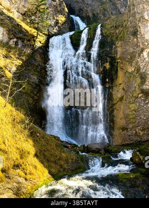 Une petite cascade parmi les montagnes rocheuses couvertes d'herbe et de mousse en Autriche Banque D'Images