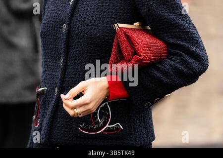Milan, Italie - 25 mars 2024 : femme porte un sac à main rouge. Détail de la tenue mode Banque D'Images