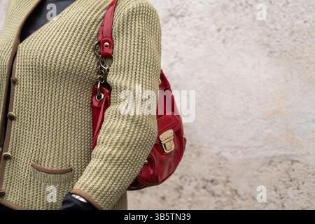 Milan, Italie - 28 mars 2024 : femme porte un sac à main rouge. Détails de tenue de mode Banque D'Images