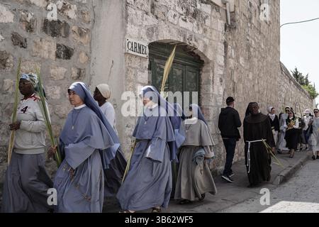 10 avril 2022, Jérusalem, Israël : des milliers de pèlerins chrétiens célèbrent le dimanche des Rameaux descendant du Mont des oliviers vers Jérusalem biblique, alors qu’ils retracent les pas de Jésus. La procession a commencé à l'église de Bethphage du IVe siècle, sur les pentes orientales du Mont des oliviers, traditionnellement le lieu où Jésus a commencé son entrée triomphale à Jérusalem, est monté au sommet puis est descendu vers l'ouest à Gethsémani, la porte Lionsâ€™ et à l'église d'Anne. (Crédit image : © Nir Alon/ZUMA Press Wire) Banque D'Images