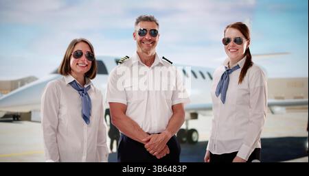 Équipage de conduite professionnel en uniforme près de Private Jet à l'aéroport Banque D'Images