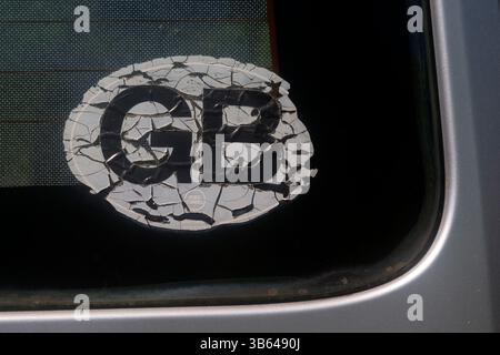 restes fissurés usés de l'autocollant de voiture gb maintenant disparu apposé sur la lunette arrière d'une vieille fourgonnette Banque D'Images