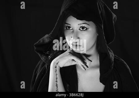 Portrait d'une jolie femme à capuche et au regard intense, photo artistique en noir et blanc, photographie de studio, Mindelheim, Unterallgaeu, Bavière, Allemagne Banque D'Images