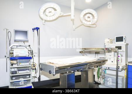 Salle d'opération vétérinaire vide équipée de lampes chirurgicales, de moniteurs, de machine d'anesthésie et d'autres technologies de pointe, préparées pour un pr chirurgical Banque D'Images