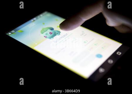 Sofia, Bulgarie - 22 juillet 2016 : un téléphone mobile montrant sur l'écran Pokemon Go jeu mobile de réalité augmentée isolé sur un fond noir. Main humaine Banque D'Images