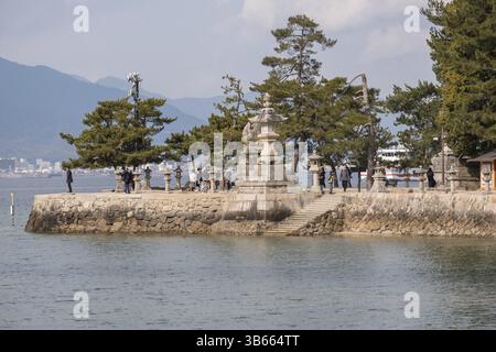 Promenade au bord de l'eau avec des lanternes en pierre sur Miyajima, Japon, Asie Banque D'Images