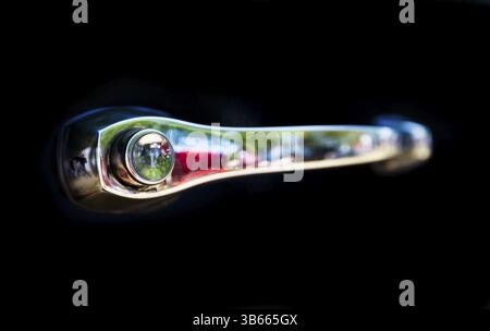 Détail d'une voiture mansardée lors d'un défilé de voitures rétro. Poignée de voiture rétro isolée sur un fond noir Banque D'Images