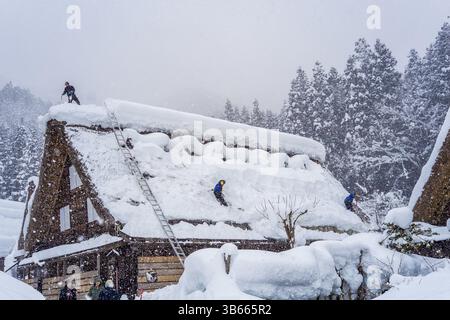 Dégagement du toit dans le village japonais enneigé de Shirakawa-Go Banque D'Images