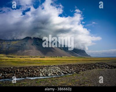 Nuages bas balayant sur les montagnes escarpées de l'est de l'Islande près de la côte Banque D'Images