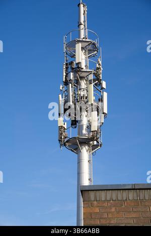 Plusieurs mâts de téléphone mobile sur le dessus du mât, fond de ciel bleu, vu à Londres Royaume-Uni Banque D'Images
