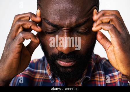 Gros plan portrait de l'homme noir fatigué qui a mal à la tête. Banque D'Images