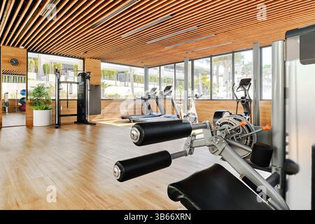 Salle moderne et bien éclairée de la salle de gym, design tendance, divers appareils d'entraînement, y compris des tapis roulants, des appareils elliptiques, des appareils de musculation. Banque D'Images