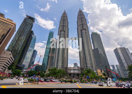 Kuala Lumpur, Malaisie - 17 février 2025 : les tours Petronas s'élèvent majestueusement au milieu de gratte-ciel modernes et d'une végétation luxuriante, avec la vie urbaine animée en contrebas Banque D'Images