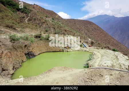 Bassin d'eaux usées toxiques provenant de l'exploitation minière de l'or dans les montagnes du Pérou, mettant en évidence l'impact environnemental dans un paysage andin éloigné. Banque D'Images