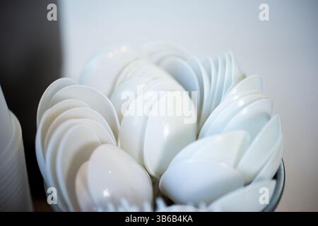 Une vue d'un récipient rempli de cuillères en plastique. Banque D'Images