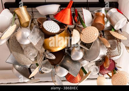 Assortiment d'outils de cuisine traditionnels suspendus comme décor dans un restaurant de l'île grecque. Banque D'Images