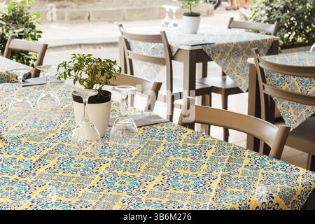 Table de restaurant élégante avec nappe jaune et bleue en Sicile, Italie Banque D'Images