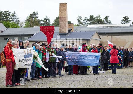 04 mai 2025, Brandebourg, Fürstenberg : de nombreuses personnes participent à la marche commémorative à l'occasion de la commémoration du 80e anniversaire de la libération du camp de concentration de Ravensbrück. Le crématorium avec la cheminée peut être vu en arrière-plan. Photo : Joerg Carstensen/dpa Banque D'Images