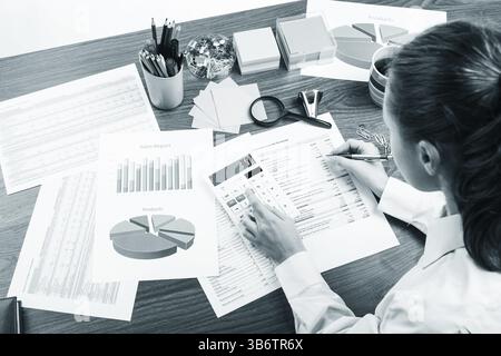 Gros plan d'une main féminine calculant, sur le bureau Banque D'Images