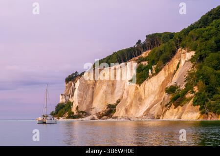 Catamaran voilier ancré près des falaises de craie de Møn au lever du soleil tôt le matin, mer Baltique, Zélande, Danemark, paysage côtier pittoresque Banque D'Images