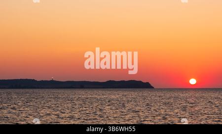 Coucher de soleil vibrant sur le phare de Dornbusch et la côte de l'île de Hiddensee, mer Baltique, Nationalpark Vorpommersche Boddenlandschaft, Allemagne Banque D'Images