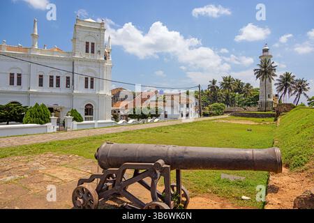 Vieux canon à Galle Fort pointant vers l'océan sous le ciel bleu et les palmiers en été Banque D'Images