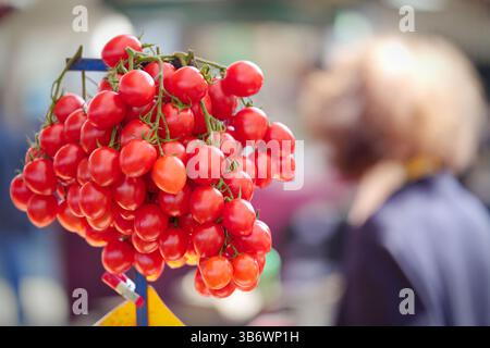 Tomates cerises rouges italiennes un jour d'été sur un marché fermier. Banque D'Images