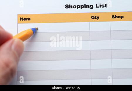 Un homme remplissant une liste de courses avec un stylo à bille. Gros plan. Banque D'Images