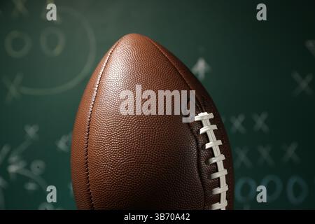 Ballon de football américain contre le schéma de jeu flou, gros plan Banque D'Images
