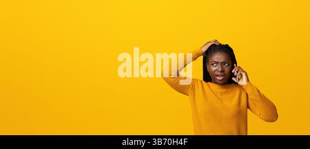 Confuse femme afro-américaine parlant au téléphone portable, réagissant émotionnellement à la conversation Banque D'Images