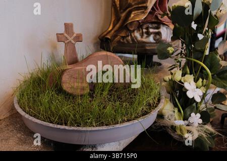 gros plan de fleurs de pensées violettes dans le jardinier et décoration de tombeau de pâques fait à la main avec de l'herbe et une croix miniature. Photo de haute qualité Banque D'Images