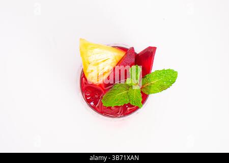 smoothie de betterave rouge ou de baies avec tranche d'ananas et garniture de menthe servi dans un verre transparent sur fond blanc. Photo de haute qualité Banque D'Images