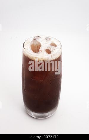 café glacé ou infusion froide dans un grand verre transparent avec des glaçons et de la mousse crémeuse servis sur fond blanc. Photo de haute qualité Banque D'Images