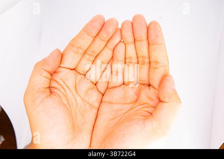 mains humaines ouvertes emboîtées ensemble photographiées sur fond blanc en geste d'offrir ou de recevoir. Photo de haute qualité Banque D'Images