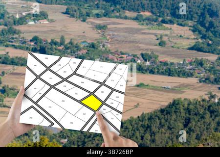 Homme détenant des lots de terrain, gestion de lot de terrain, concept immobilier avec terrain vacant pour la construction de bâtiments et lotissement résidentiel à vendre, Re Banque D'Images