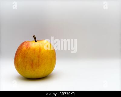 Pomme jaune juteuse fraîche avec bâton sur le dessus sur fond blanc à gauche dans la vue de face de l'image Banque D'Images