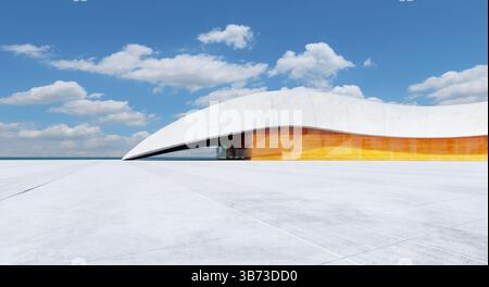 Bâtiment futuriste blanc et orange avec toit incurvé se dresse sur esplanade en béton au bord de la mer sous ciel bleu avec des nuages. Rendu 3D. Banque D'Images