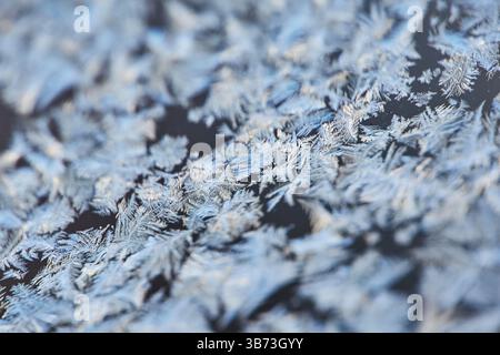 Motifs de gel : formations de glace abstraites sur une fenêtre. Plan détaillé mettant en évidence les motifs délicats et givrés formés par les températures glaciales. Banque D'Images